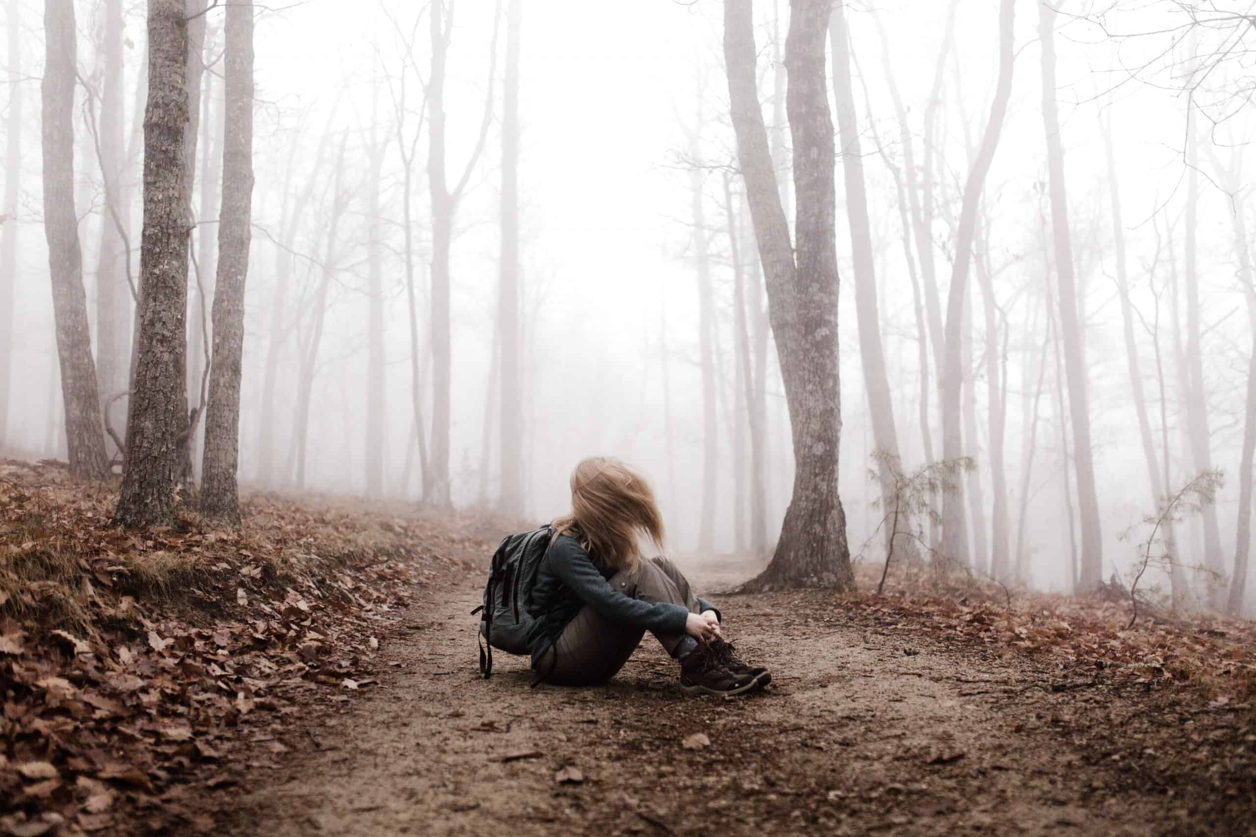person feeling trapped sitting on woodland path
