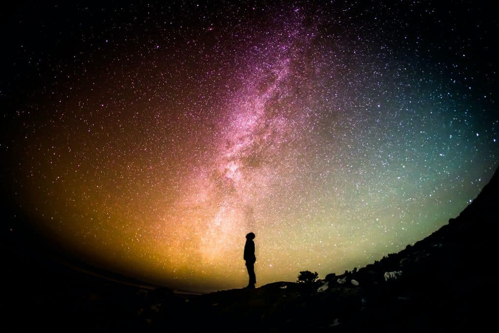 Silhouette of person in front of galaxy