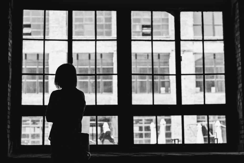 Help for those who feel like they don't fit in anywhere 2 black and white photo of woman staring out of window