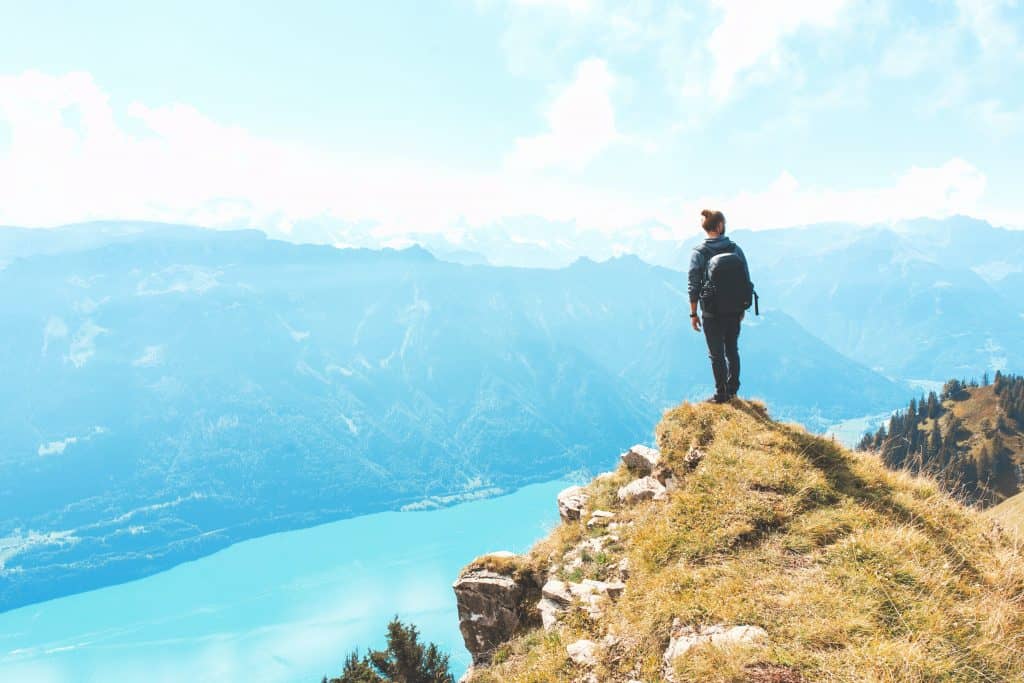 man standing on the edge of a cliff overlooking the scenery