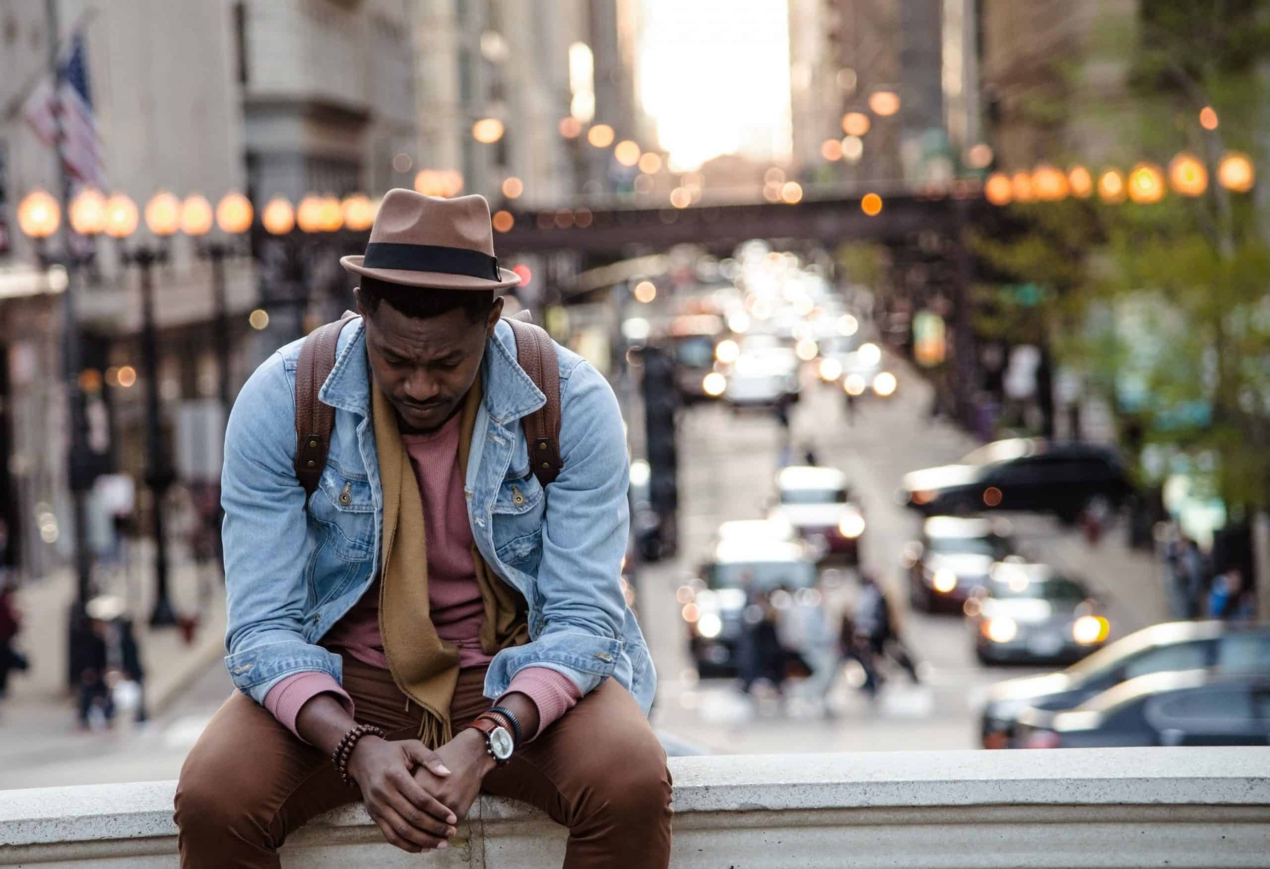My Life Sucks - Bounce Back Guide 5 Man sat looking defeated with busy blurred city scene in background