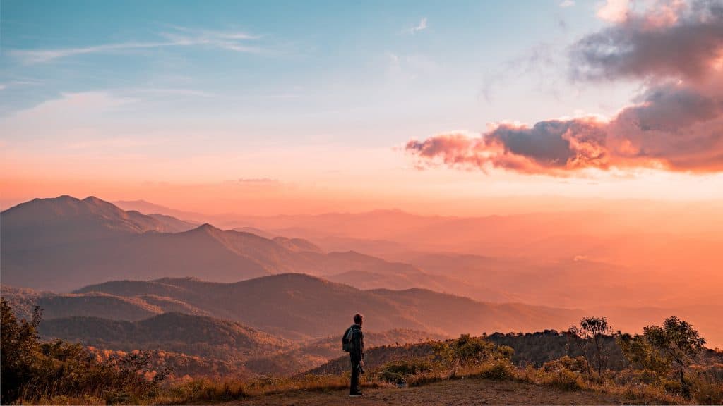 Accepting what is and accepting life 3 Man stood overlooking sunset across mountain range