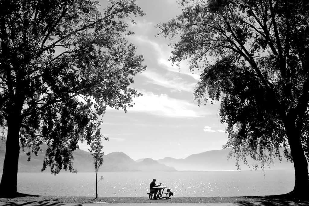 Ways to cope when people let you down 2 Man sat at picnic table in front of a lake surrounded by trees