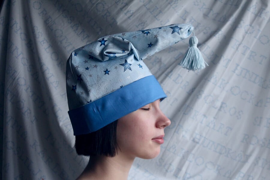 Woman with sleeping cap on experimenting with what happens to your brain when you sleep