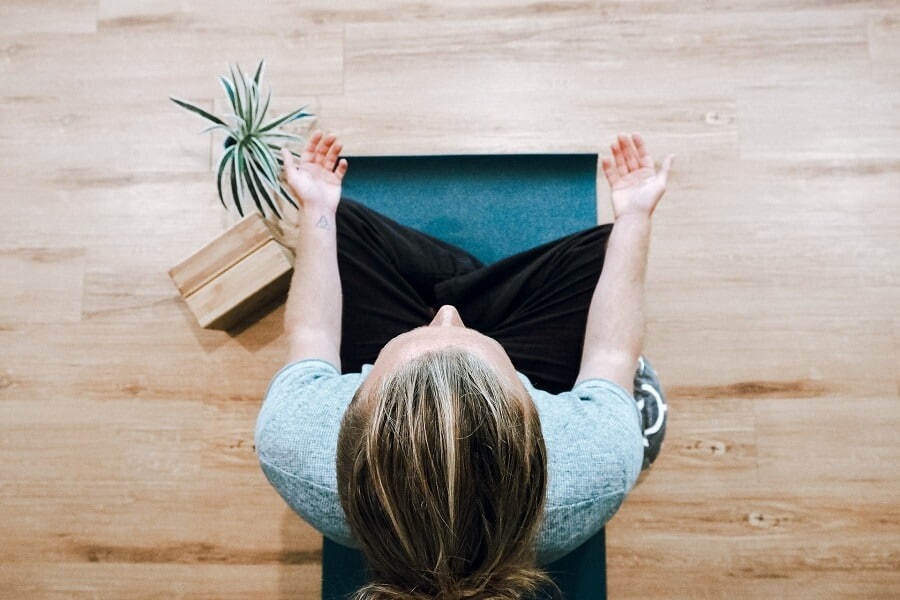 Being present and staying in the moment 3 Woman on matt meditating