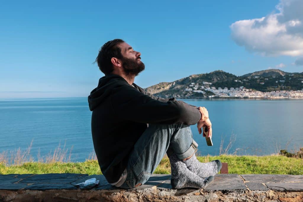 Tips for Effectively Managing Stress 2 a man taking time out by the sea to practice managing stress