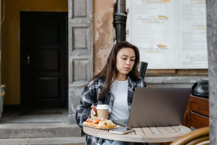 a woman managing to stay focused working outside a cafe