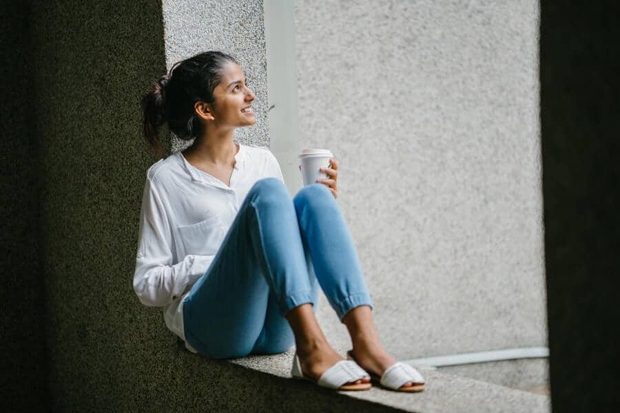 Woman sitting and smiling with cup of coffee
