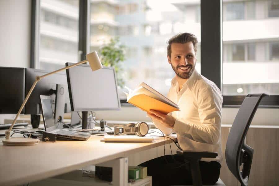 12 Ways To Beat The Sunday Blues 6 Man at desk smiling