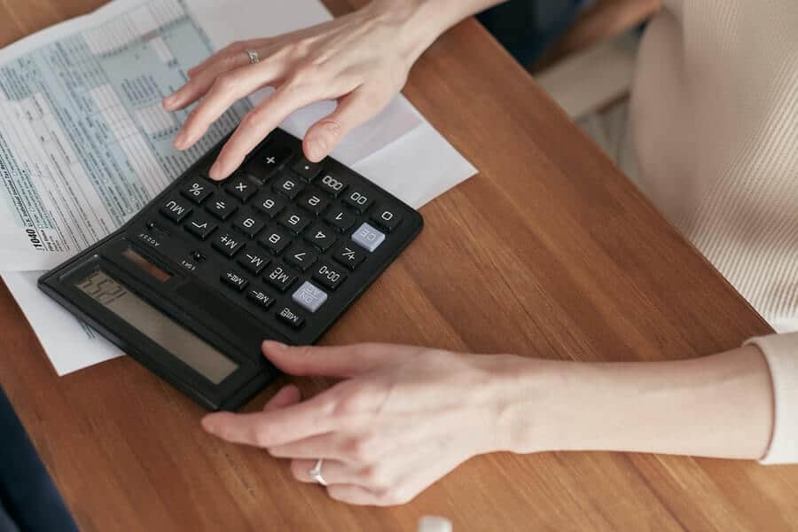 Is Money Addiction Real? How To Break Bad Spending Habits 13 person using calculator
