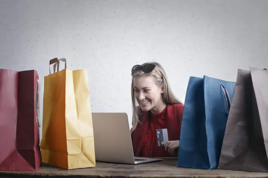Is Money Addiction Real? How To Break Bad Spending Habits 2 a woman with money addiction surrounded by shopping bags