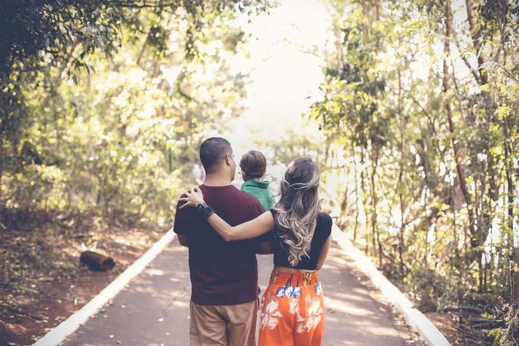 Loneliness as a Parent: Finding Meaning When You Feel Alone 1 A family enjoying a leisurely walk on a sunny park trail, showcasing togetherness and love.